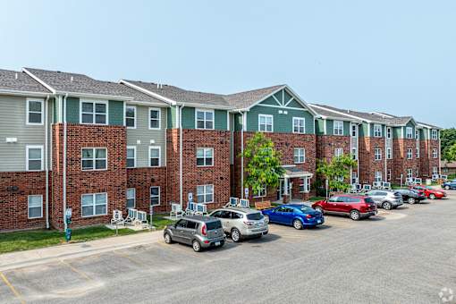 A parking lot with cars and apartment buildings in the background.