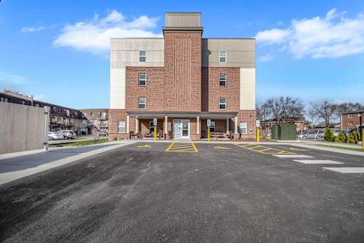 A large brick building with a parking lot in front.