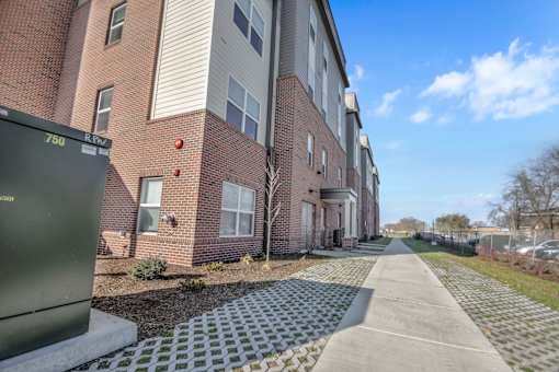 A brick apartment building with a green sign that says 750 on the left.