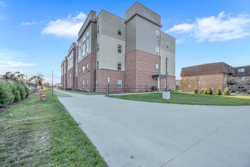 A large brick building with a red fire hydrant on the sidewalk.