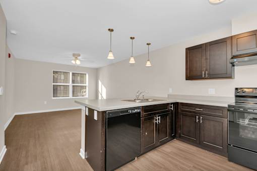 A kitchen with dark wood cabinets and a white counter top.