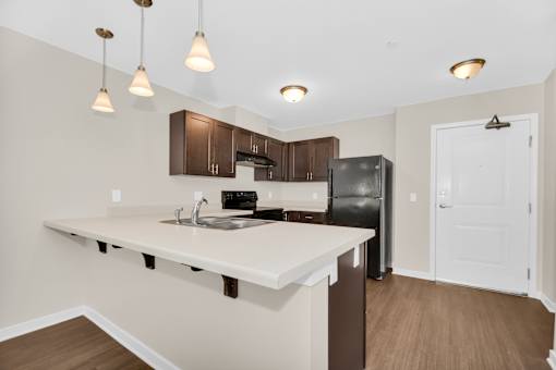 A kitchen with a white counter top and brown cabinets.