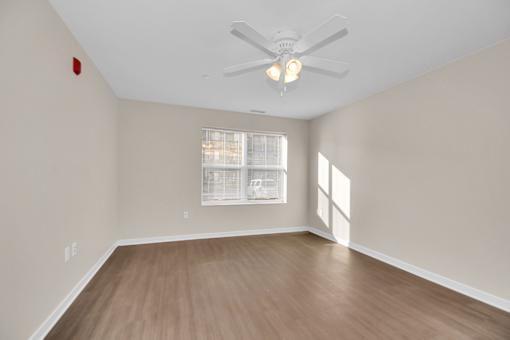 A room with a ceiling fan and a window.