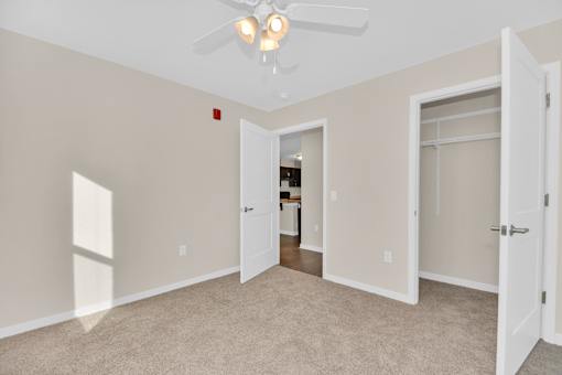 A room with a ceiling fan and carpeted floor.