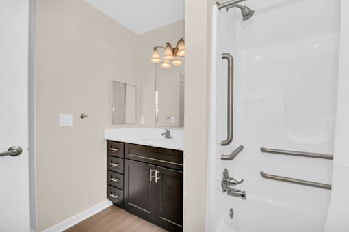 A bathroom with a white tub and a white sink.