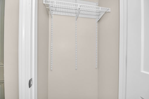 A white metal shelf bracket is mounted on a wall.