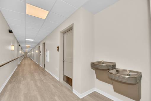 A long hallway with two sinks on the wall.
