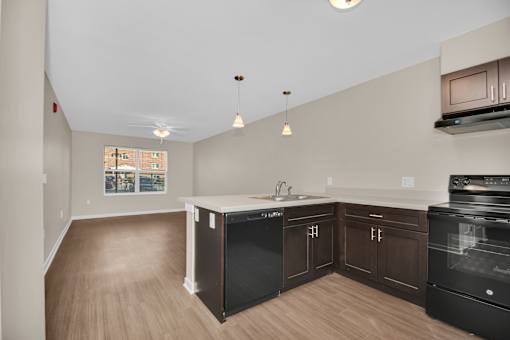 A kitchen with black appliances and wooden cabinets.