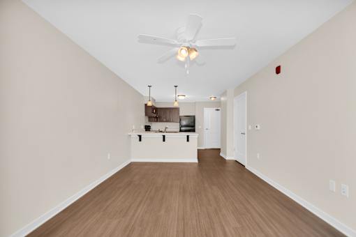 A room with a ceiling fan and a wooden floor.