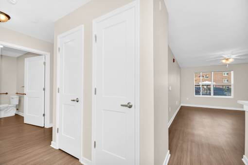 A room with white doors and a brown floor.