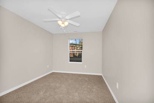 Empty room with a ceiling fan and a picture on the wall.