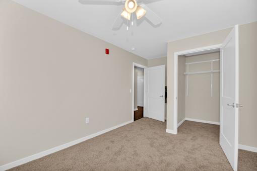 A room with a ceiling fan and two doors.