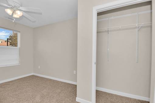 A room with a ceiling fan and a large open door.