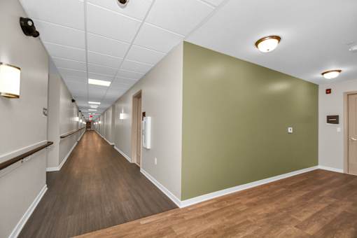 A long hallway with wood floors and white walls.