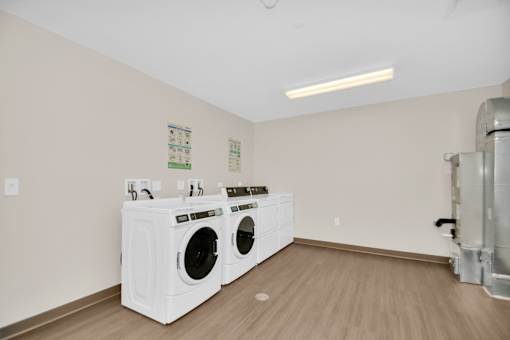 A laundry room with two front loading washing machines.