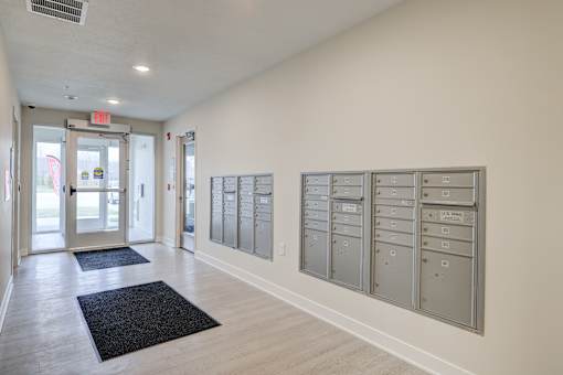 A hallway with a row of mailboxes on the wall.