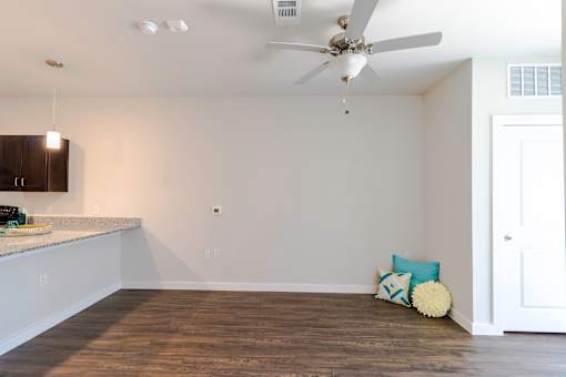 A room with a ceiling fan and a white door.