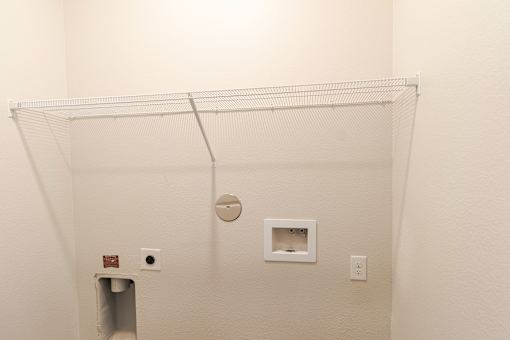 A white wall with a small square hole and a small square window.
