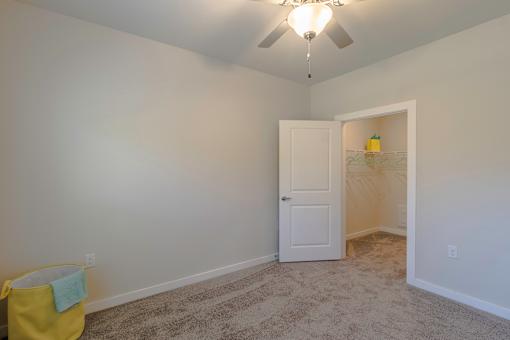 A room with a ceiling fan and a door.