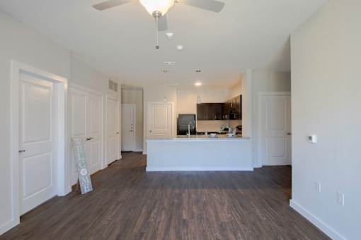 A large open space with a kitchen island and a fan.