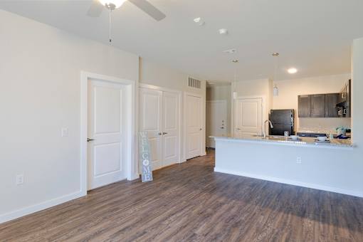 A spacious living room with a white reception desk and a wooden floor.
