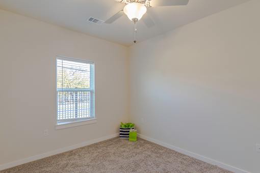 A room with a window and a ceiling fan.