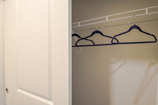 Three hangers are hanging on a wire rack.