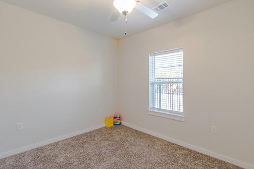 A room with a window and a ceiling fan.