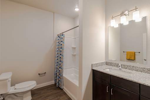 A bathroom with a toilet, sink, and shower.