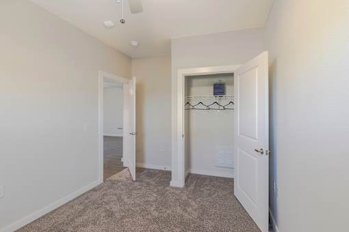 A room with a carpeted floor and a white door.