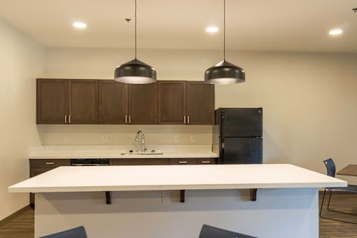 A modern kitchen with a white countertop and dark brown cabinets.