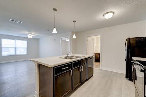 A kitchen with a sink, stove, and refrigerator.