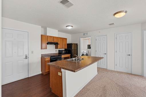 A kitchen with white walls and a brown island.