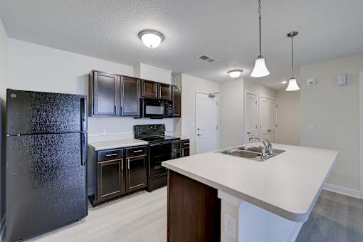 A kitchen with black appliances and white countertops.