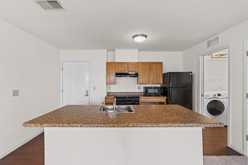 A kitchen with a granite countertop and stainless steel appliances.