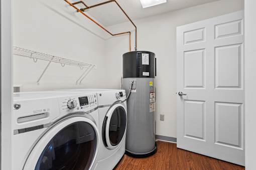 A laundry room with a washer and dryer and a water heater.