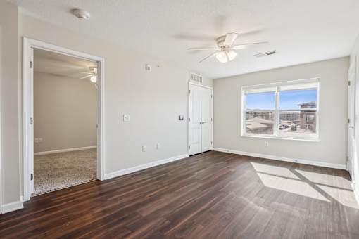 A room with a window and a ceiling fan.