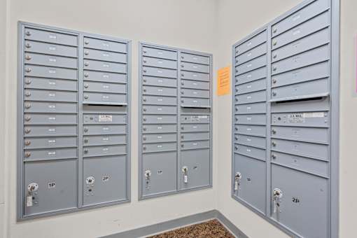 A row of mailboxes are lined up against a wall.