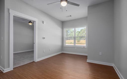 A room with a window and a ceiling fan.