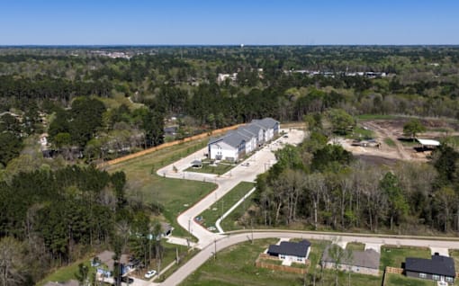 A road curves through a residential area with houses on either side.
