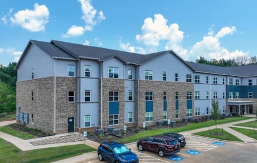 A large building with a parking lot in front of it.