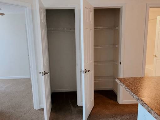 A kitchen with a white door and a brown counter.