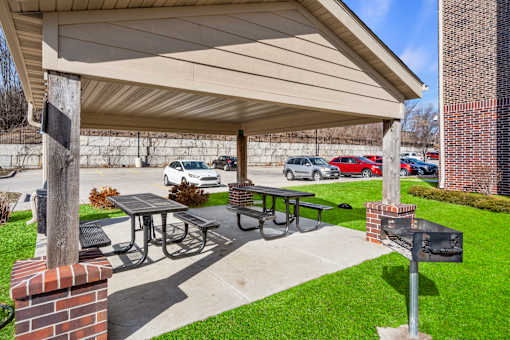 A covered picnic area with tables and a grill.