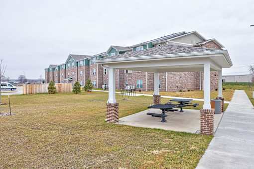 A covered picnic area in front of apartment buildings.