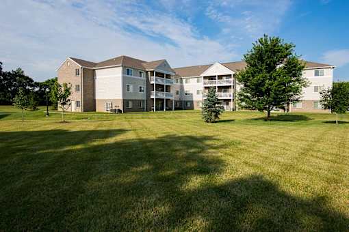 A large grassy field in front of a building.