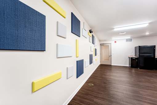 A hallway with a series of paintings on the wall.