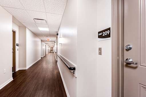 A hallway with a sign that says "Unit 209" on the wall.