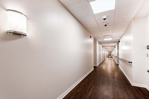 A long hallway with a light on the wall and a skylight above.