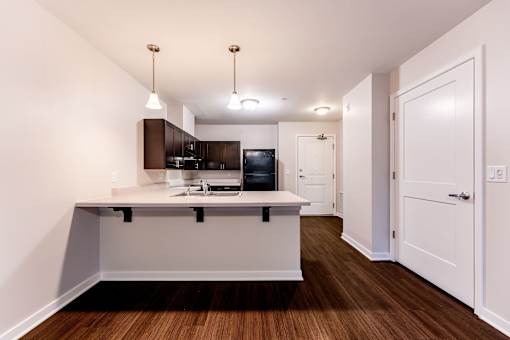 A kitchen with a white counter and brown cabinets.
