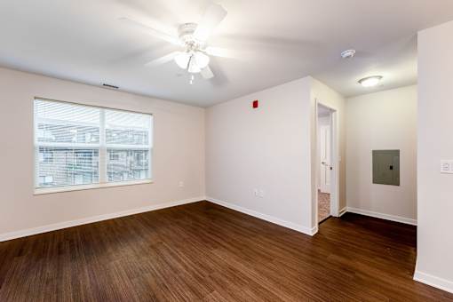 A room with a ceiling fan and a window.